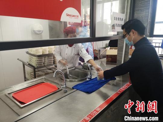员工领取预防中药汤剂。　刘曼 摄