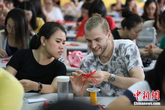 华南师范大学外国留学生学习打中国结。中新社发 李宁 摄

