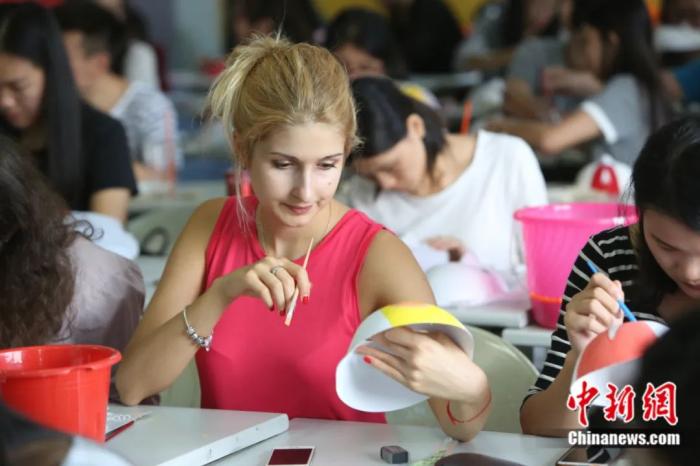 华南师范大学外国留学生学习画脸谱。中新社发 李宁 摄

