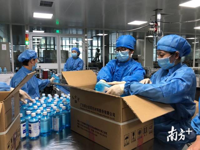 工人们在传统直线灌装车间内做最后的包装。